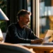 Best Phone System for Small Business- 2026 Buyers Guide | Alliance Virtual Offices Small business owner working on a laptop beside a desk phone, choosing a 2026 phone system