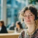 Live Receptionist Service- The Complete Guide Costs Features Setup and In-House Alternatives | Alliance Virtual Offices A live receptionist wearing a headset smiles confidently while working at a modern, well-lit office with colleagues in the background