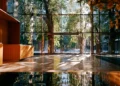 Modern virtual office building lobby with floor-to-ceiling glass windows, warm wood reception desk, and polished reflective floors overlooking a tree-lined city street
