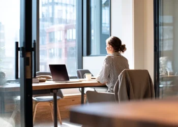 LLC owner working remotely from a modern virtual office space, considering registered agent and business address options
