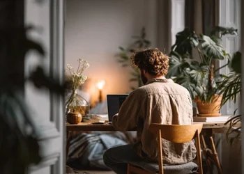 Remote worker using laptop at home desk, illustrating the need to keep home address off public records