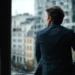 How to Open a Business Address Anywhere in the US Without Moving - A Consultants Guide | Alliance Virtual Offices Business consultant looking out an office window at a city skyline, considering expansion to a new U.S. market