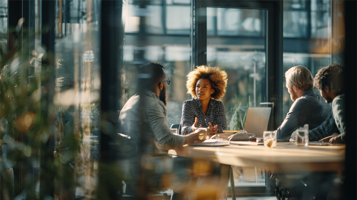 Meeting Room Rental Pricing in 2026- What You Need to Know | Alliance Virtual Offices Three professionals having a meeting in a modern glass-walled conference room, representing meeting room rental options for businesses.