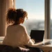 HUMANIZED Virtual Phone System for Small Business | Alliance Virtual Offices Woman working on laptop at home office desk with city view window, using virtual phone system for small business