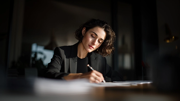 How to Build Business Credit Without Personal Credit | Alliance Virtual Offices Female entrepreneur reviewing financial paperwork at her desk in a quiet office