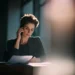 Tax Season Call Management for Accounting Firms- How to Handle the 300 Volume Spike | Alliance Virtual Offices Accountant reviewing tax documents while answering a client call during peak tax season
