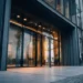 Street-level close-mid shot of a clean modern commere: Should I Use My Home Address for My LLC? | Alliance Virtual Offices Clean modern office building exterior at street level — illustrating why using a professional business address instead of a home address for your LLC matters