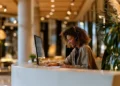 Live receptionist in a headset taking notes while answering calls at a modern front desk