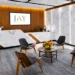 Answering Service New York- Local Live Call Answering for NYC Businesses | Alliance Virtual Offices Reception and waiting area with a marble front desk, wood-panel wall, backlit marble panels, and four molded wood chairs around a round coffee table