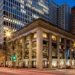 Conference Room Rental Chicago- How to Book Professional Meeting Space by the Hour | Alliance Virtual Offices Chicago street corner at night: classical columned building with ground-floor shops and office towers behind