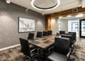 Meeting room with a wood conference table, black leather chairs, ring pendant light, and a framed city map print