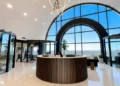 Modern office lobby with a round reception desk and panoramic arched windows