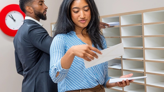 Can You Use a PO Box for an LLC as Your Business Address | Alliance Virtual Offices Business professionals sorting mail at a mail room pigeonhole unit in a staffed office