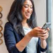 How to Get a Vanity Phone Number for Your Business 2026 Guide | Alliance Virtual Offices Business owner checking messages on her phone in a bright office space