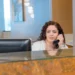 Receptionist answering a call at a front desk in a professional office lobby