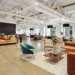Coworking lounge with sofas, armchairs, and large windows in a modern office building